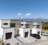 Poprad apartment buildings with the panorama of the High Tatras on the horizon, surrounded by nature.