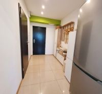 A hallway with light tiles and modern storage space in a 2-room apartment.