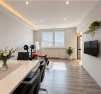 Spacious living area with dining table, wooden decor flooring, 4-room apartment.