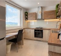 A kitchen with a wooden decor floor in a 4-room apartment, bright and spacious.