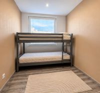 A room with a bunk bed in a four-room apartment, floor with wooden decor.
