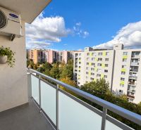 View from the balcony of a 4-room apartment on Halalovka in Trenčín, houses and greenery.