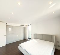 A bedroom in a 4-room apartment with a wooden decor floor and a built-in wardrobe.