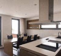 A kitchen in a 4-room apartment with a cooking island and a dining table.