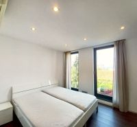 A bedroom with light-colored walls, a double bed, and a wood-patterned floor in a four-room apartment.