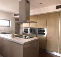 A 4-room apartment kitchen with an island and appliances, floor with wood decor.