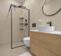 A bathroom in a family house with a shower, a sink, a mirror, and wooden decor.