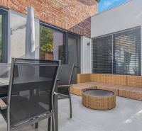 Family house with a terrace, rattan seating, and a dining table.