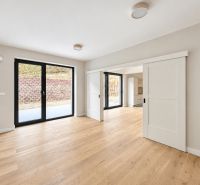 A family house with large sliding doors and a floor with a wood decor.