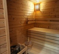 The interior of a sauna in a family house with wooden paneling and benches.