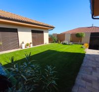 The garden of a family house in Martin nad Žitavou with a lawn and a terrace.