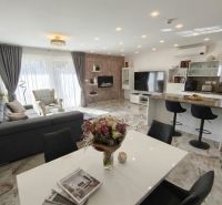 Living room in a family house with spacious seating, dining table, and decorative elements.