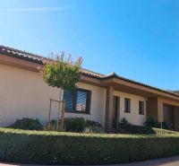 A family house in Martin nad Žitavou with a landscaped garden and flower beds.