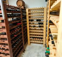 A wine cellar in a family house with wooden racks and a wine barrel.