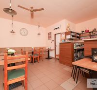 Commercial premises with wooden tables, wall clocks, and a bar counter.