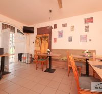 Interior of commercial spaces with furniture, wall decorations, and beer kegs.