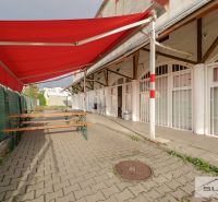 The exterior of commercial premises with a red awning on Korytnická Street, Bratislava - Podunajské Biskupice.
