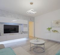 Living room with white gloss furniture and a wood-decor floor.