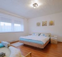 A bedroom in a 4-room apartment with a double bed and a floor with a wooden decor.