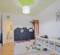Children's room in a 4-room apartment with a wooden decor floor, toys, and storage boxes.