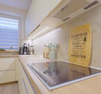 A bright kitchen with an induction cooktop, wall decoration, and appliances in a 4-room apartment.
