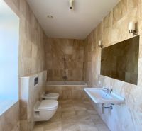 The bathroom in the 3-room apartment on Hlboká Street has a bathtub, a mirror, and a sink.