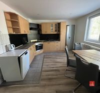 A kitchen in a 4-room apartment with a corner unit and a floor with a wooden decor.