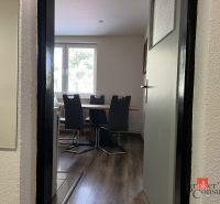 Wooden floor decor in the dining room of a 4-room apartment with a dining table and chairs.