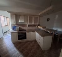 A kitchen in a family house with a kitchen unit, appliances, and a dining area.