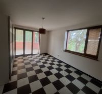 A room in a family house with black and white tiles and large windows.