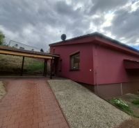 A family house on Chmeľová dolina in Zobor with a red facade and a paved walkway.