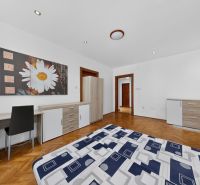 Interior of a 3-room apartment with a wooden decor floor and simple furniture.