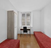 A bright room in a 3-room apartment with a wood-patterned floor and simple furniture.