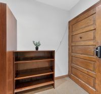 The entrance hall in a 3-room apartment with wooden doors and a shelf.