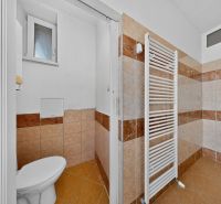 A bathroom in a 3-room apartment with a towel radiator and tiles.