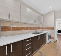 A kitchen in a 3-room apartment with ceramic tiles and built-in cabinets.