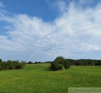 Green meadows and forests around Hrušov under the blue sky.