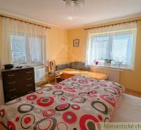 A bedroom in a family house with decorative bedding and light-colored walls.