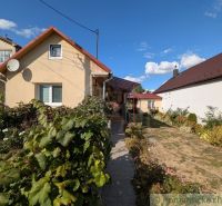 A family house in Cabov with a landscaped garden and a red roof under a blue sky.
