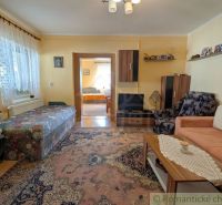 Living room in a family house with a carpet, sofa, and armchair.