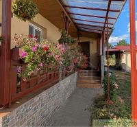 A family house in Cabov with a front porch surrounded by flowers and interlocking paving.