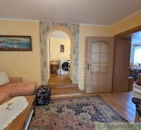 Living room in a family house with an arched passage and a wooden decor floor.