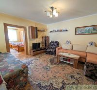 Living room of a family house with a comfortable sofa and a view into the bedroom.