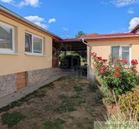 A family house in Cabov with rose bushes and a paved walkway.