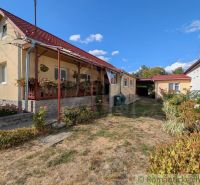 A family house in Cabov with a renovated porch and a flower bed in the garden.