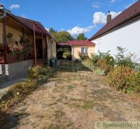 A family house in Cabov with a veranda and a garden full of flowers and greenery.