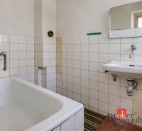 A bathroom in a family house with an older bathtub and sink.