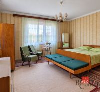 A bedroom with retro furniture and floral patterns in a family house.