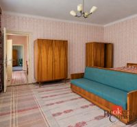A room in a family house with retro furniture and patterned wallpaper.