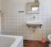A bathroom in a family house with white tiles and simple sanitary ware.